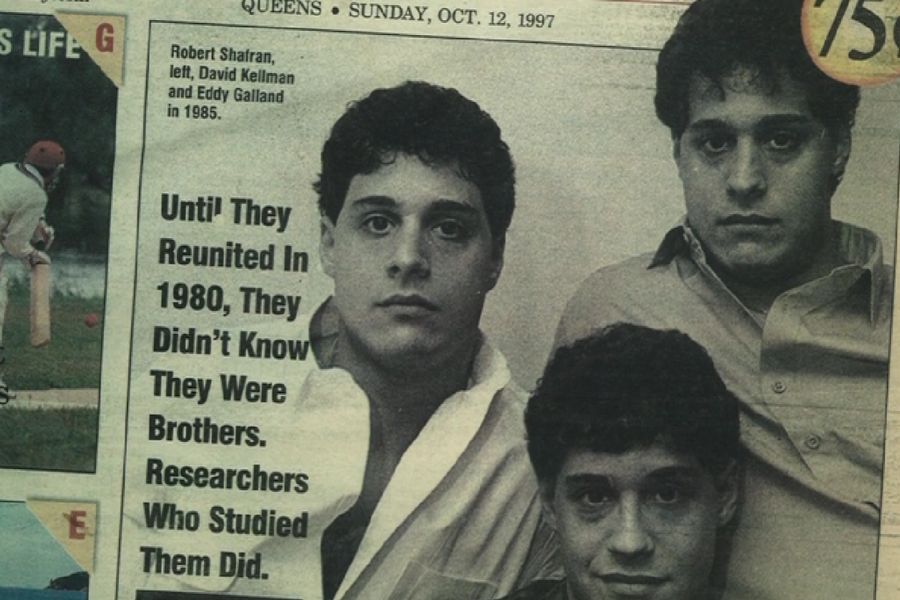 Newspaper clipping dated October 12, 1997, featuring a photo of triplets Robert Shafran, David Kellman, and Eddy Galland from 1985. Bold text reads: "Until They Reunited In 1980, They Didn’t Know They Were Brothers. Researchers Who Studied Them Did."
