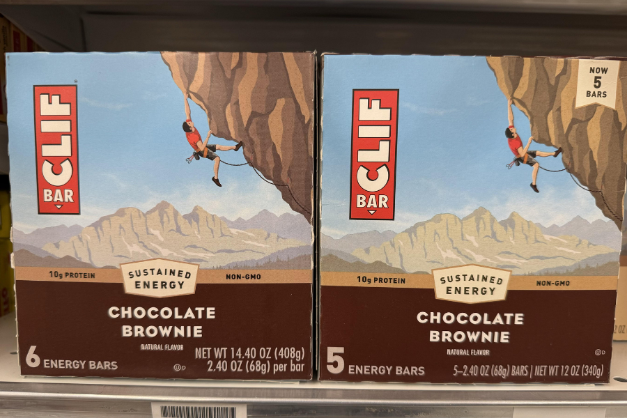 Two boxes of Clif Bar Chocolate Brownie energy bars side by side, one with 6 bars and the other with only 5, both featuring the same packaging design.