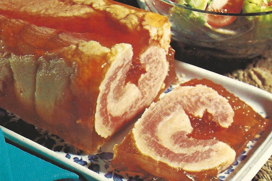 A swirl of meat or ham embedded in amber gelatin, sliced to show the spiral pattern, served cold on a decorative platter.