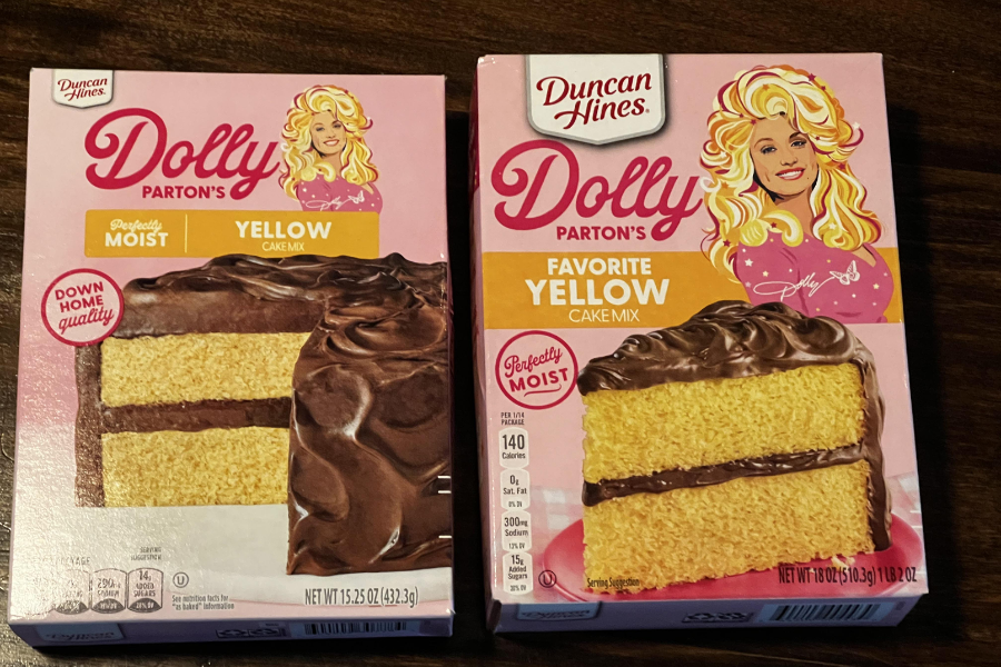 Two Duncan Hines Dolly Parton yellow cake mix boxes with slightly different designs and names, one labeled “Perfectly Moist Yellow” and the other “Favorite Yellow.”