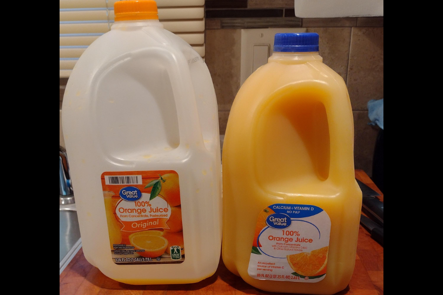 Two Great Value 100% Orange Juice bottles with different designs and label styles, one in a translucent jug and one in a fully opaque orange-tinted jug.