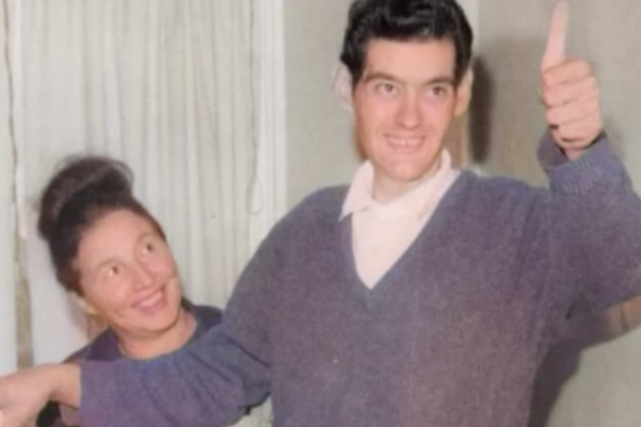 Colorized photo of a happy man giving a thumbs up while standing in oversized pants, with a smiling woman beside him holding the waistband.