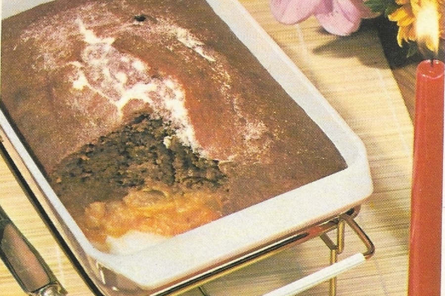 A rectangular dish showing a thick, brown, crusty-topped casserole with a scoop removed to reveal layers of ground beef and melted cheese.