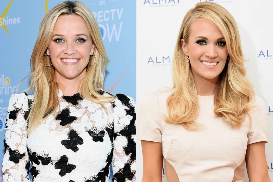 Side-by-side photo of two women with long blonde hair smiling at the camera. The woman on the left wears a white lace dress with black floral patterns, while the woman on the right wears a pale pink fitted dress.