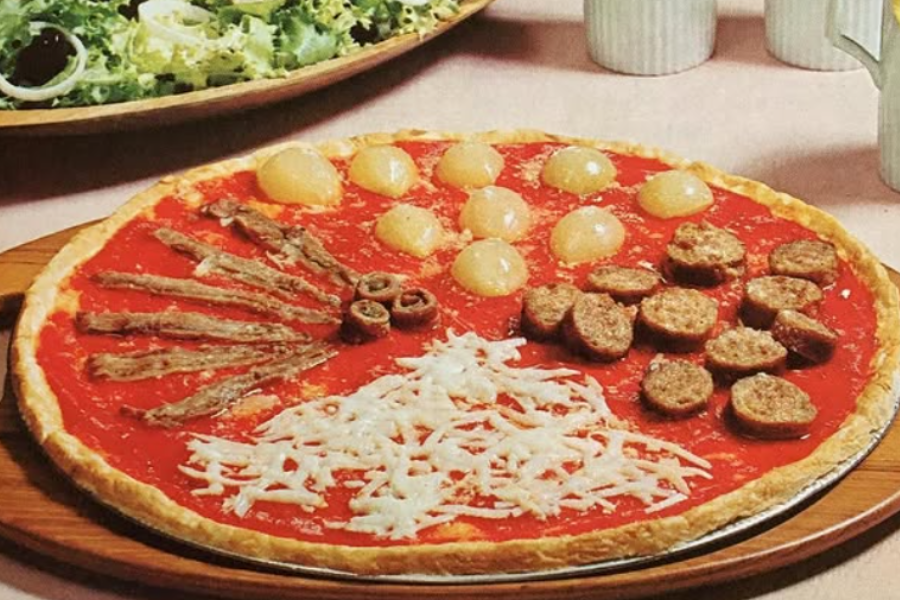 A pizza with tomato sauce base divided into distinct topping sections including cocktail onions, anchovies with olives, shredded cheese, and sausage slices.