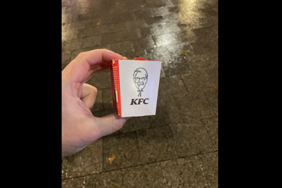 A small KFC-branded cardboard container held in someone's hand, appearing significantly smaller than typical takeaway sizes.