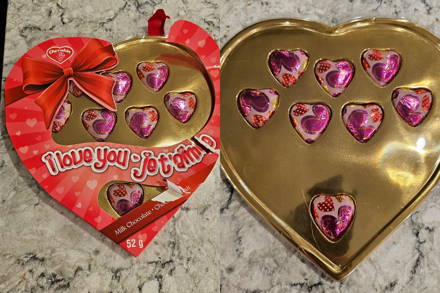 A heart-shaped chocolate box with decorative packaging saying "I love you - je t'aime" showing only seven small chocolates inside a large tray.