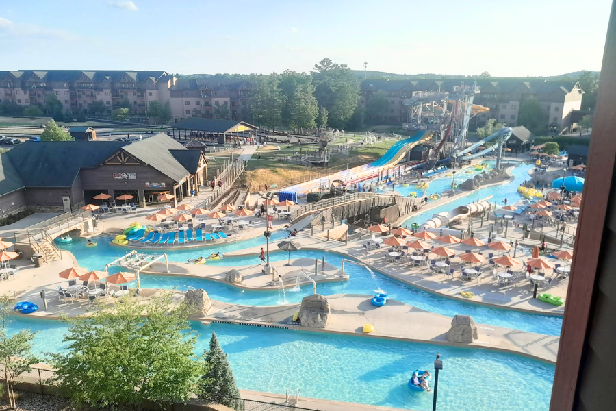 An expansive outdoor waterpark with lazy rivers, tall water slides, and orange umbrellas at Wilderness at the Smokies Resort.