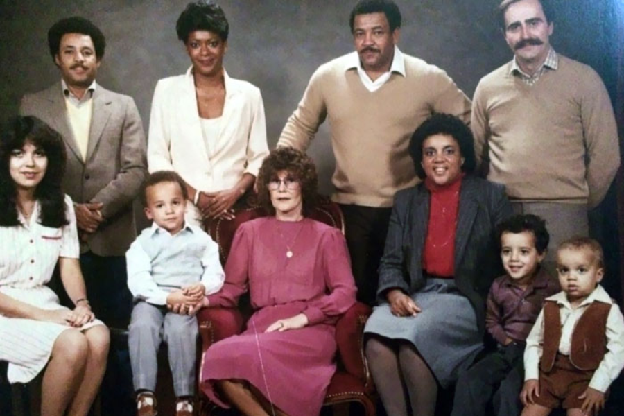 A formal family portrait features various expressions and outfits from the 1980s, giving it a wonderfully nostalgic and awkward charm.