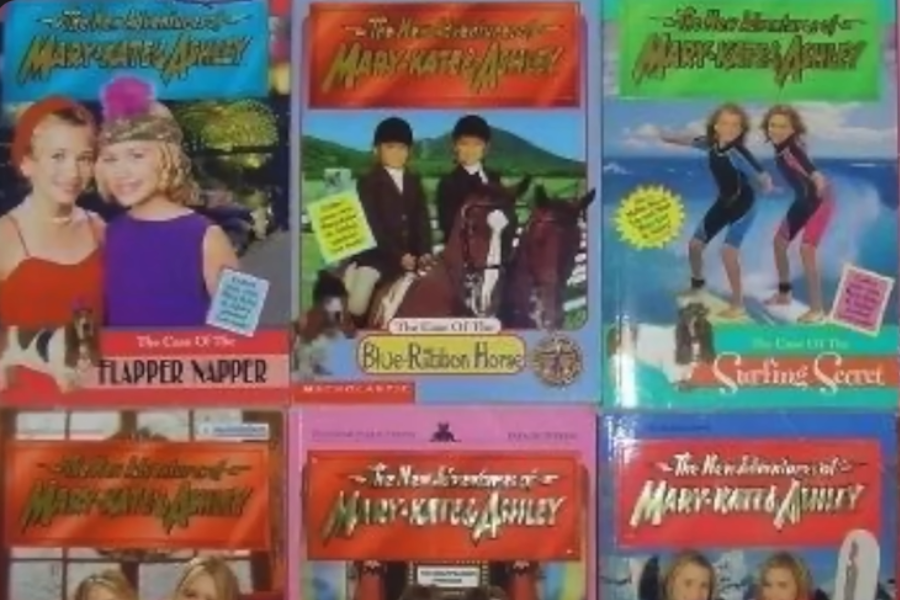 A colorful display of “The New Adventures of Mary-Kate & Ashley” book covers, featuring themed mysteries like “The Case of the Flapper Napper” and “The Surfing Secret.”