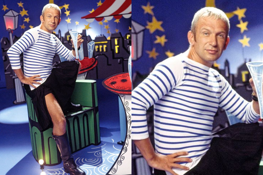 Man with bleached hair and a mischievous smile wears a blue-and-white striped top and black kilt, lifting one leg over a bench while holding a cocktail glass. Whimsical background features stars, buildings, and circus elements.