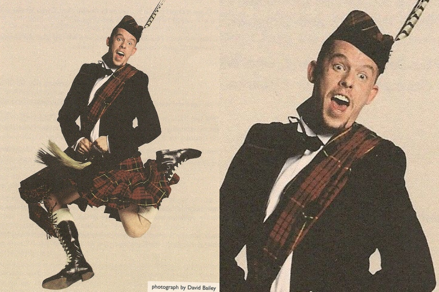 Man mid-air in a joyful leap wearing traditional Scottish Highland attire including a tartan kilt, sash, and feathered cap, with an animated expression. Close-up captures his playful personality.