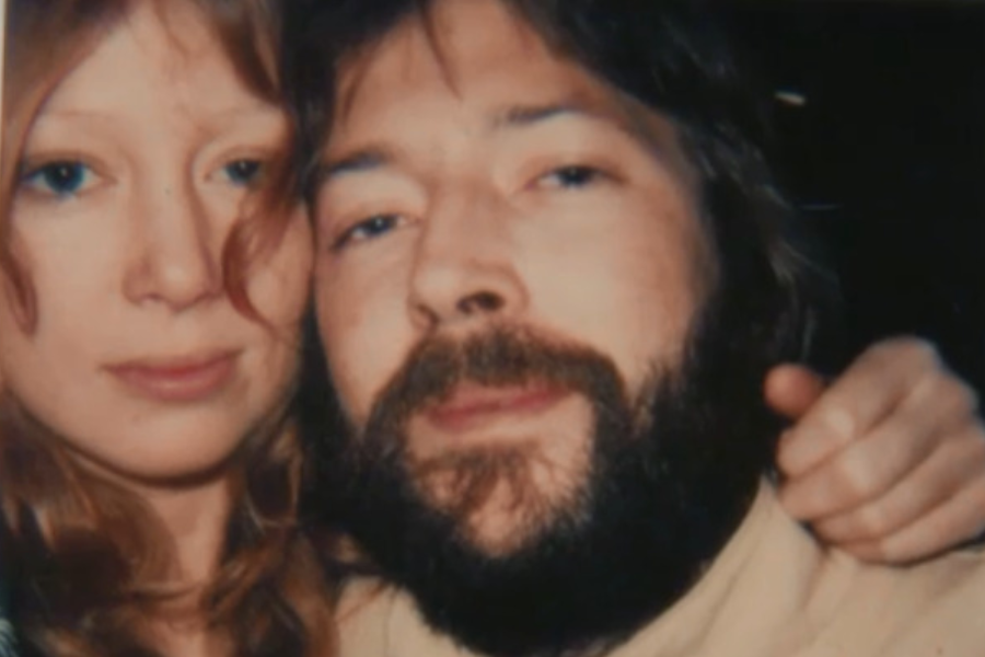 Close-up polaroid-style photo of Pattie Boyd and Eric Clapton, with her arm around his shoulder in a soft, intimate pose.