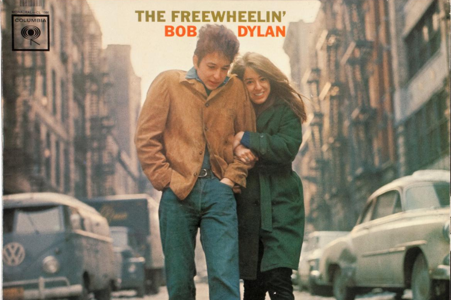 Cover of "The Freewheelin' Bob Dylan" album showing Bob Dylan and Suze Rotolo walking arm-in-arm down a snowy New York City street, both smiling warmly.