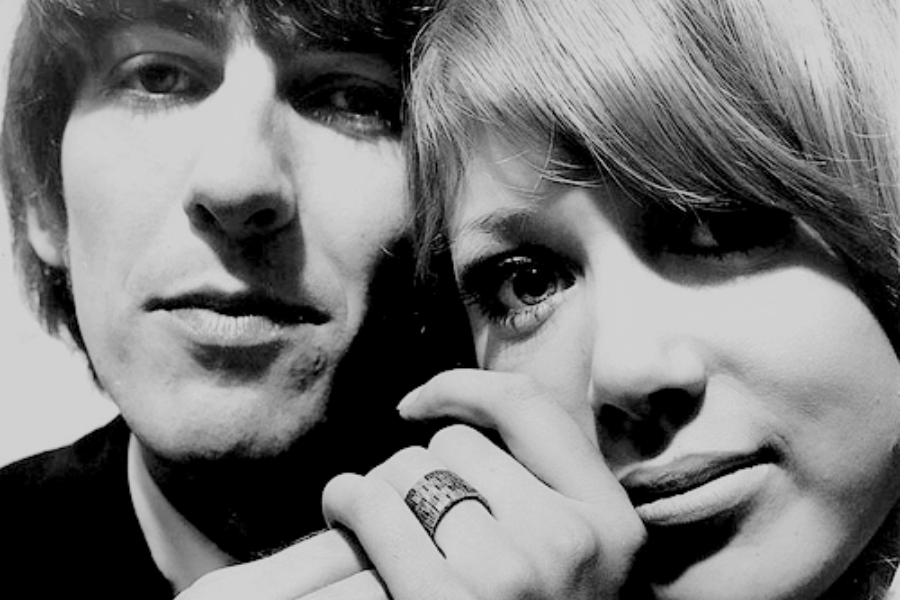Close-up black-and-white portrait of George Harrison and Pattie Boyd, with their hands intertwined and her wearing a textured ring.