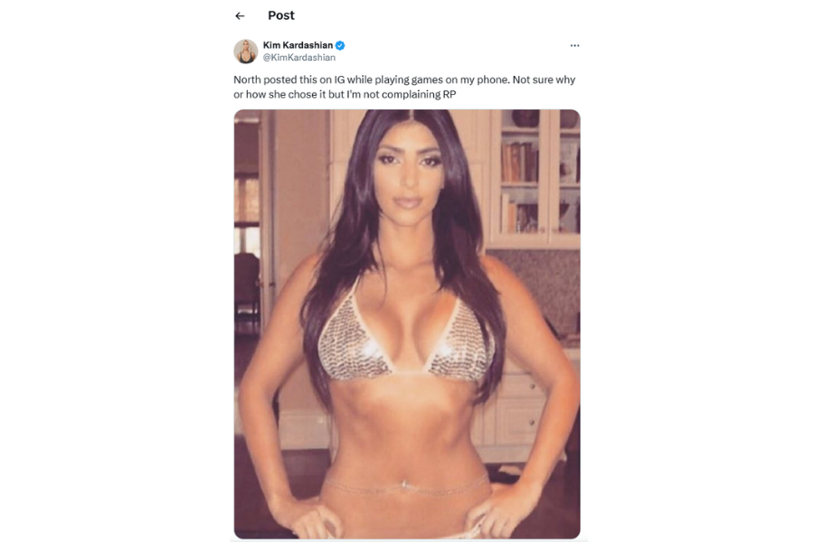 A woman with long dark hair poses confidently in a leopard print bikini. She is standing in a room with shelves and cabinets behind her. The tweet above humorously mentions the image was posted online by accident. The caption reads "North posted this on IG while playing games on my phone. Not sure why or how she chose it but I'm not complaining RP"