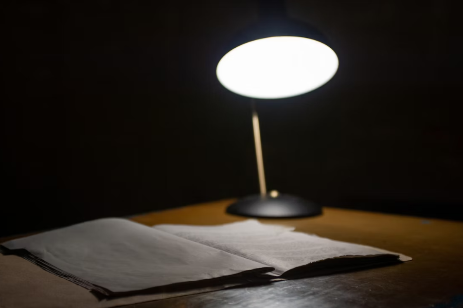 Black table lamp beside book