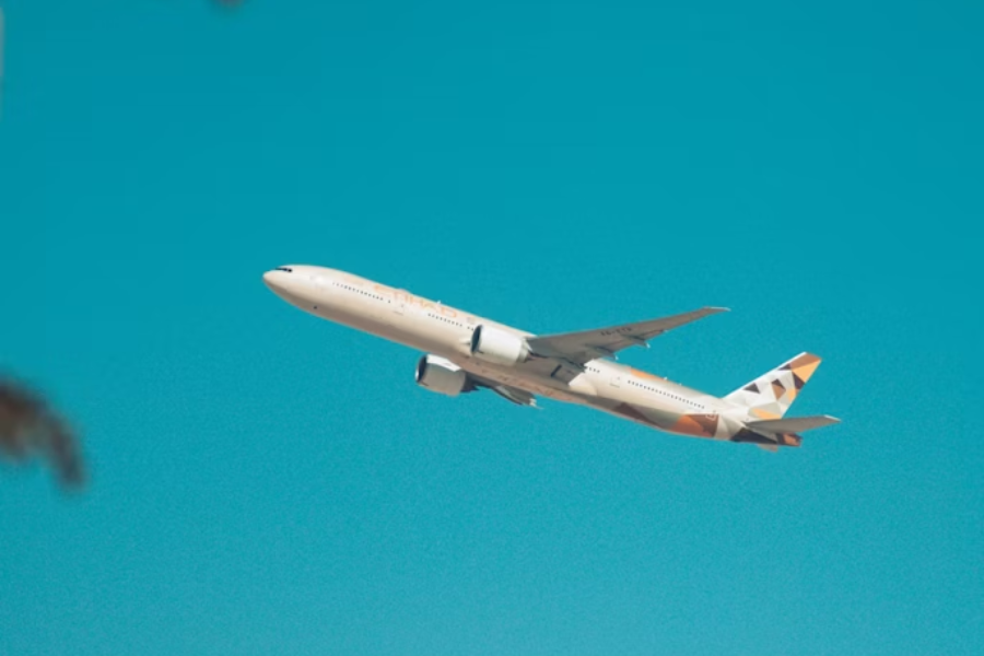 Commercial plane fliying in blue sky, sunny day. 