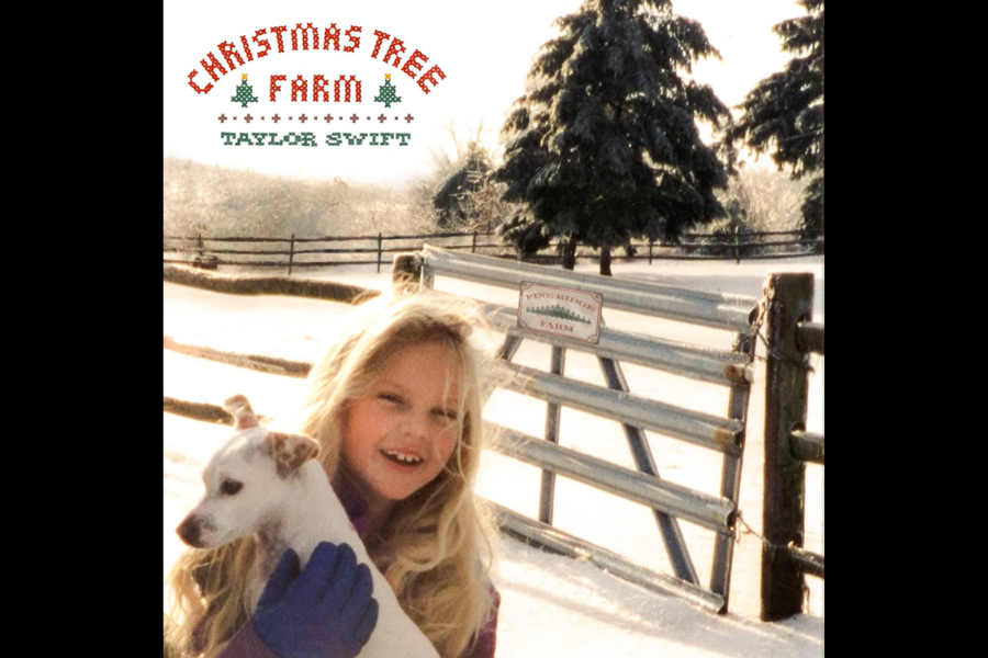 A young girl with long blonde hair smiles while holding a small dog on a snowy path. Behind them is a wooden fence and evergreen trees. The text reads "Christmas Tree Farm, Taylor Swift."