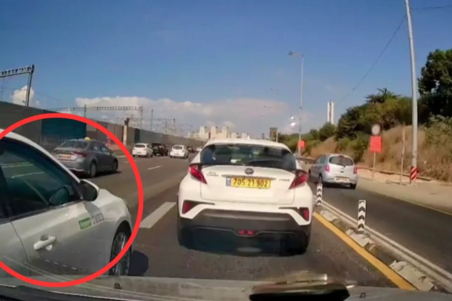 Traffic scene showing a car in a red circle crossing into a lane illegally during highway congestion.