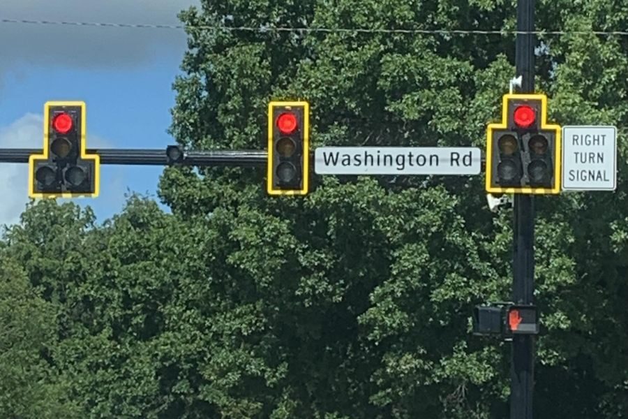 Three red traffic lights above an intersection with a Washington Rd street sign and a “Right Turn Signal” sign.